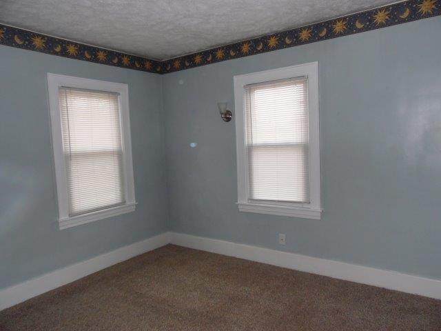 carpeted empty room featuring a textured ceiling