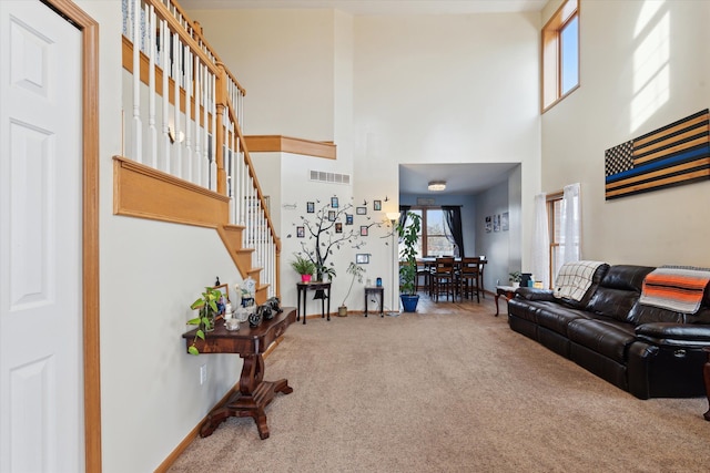 living room featuring a high ceiling and carpet flooring