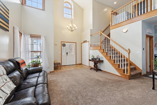 carpeted living room featuring plenty of natural light, a towering ceiling, and an inviting chandelier