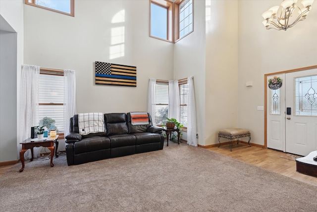 carpeted living room with a notable chandelier and a high ceiling