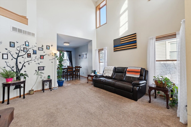 carpeted living room with a towering ceiling