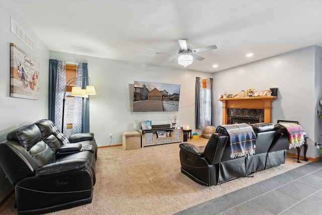 carpeted living room with ceiling fan and a premium fireplace