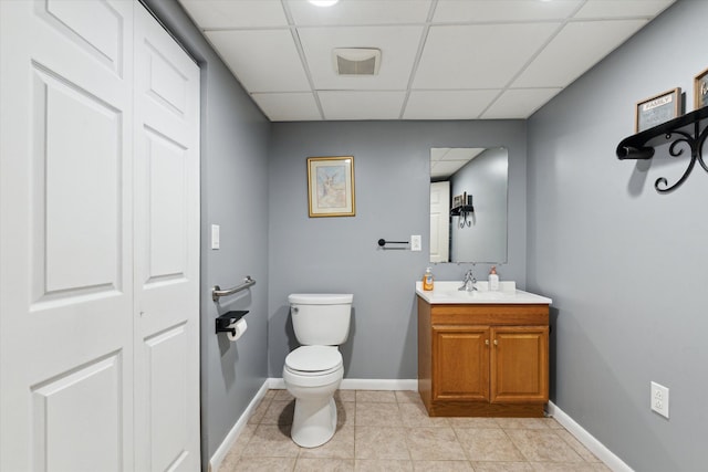 bathroom featuring tile patterned floors, toilet, a paneled ceiling, and vanity