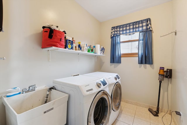 washroom featuring sink, light tile patterned flooring, and washer and dryer