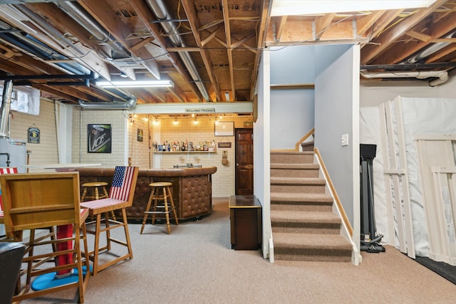 basement with indoor bar and carpet