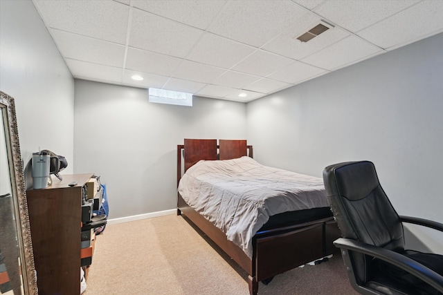 bedroom with a drop ceiling and carpet