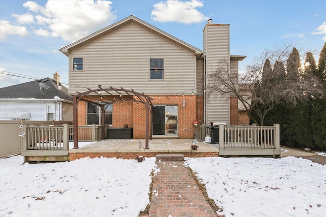 snow covered property featuring a deck and a pergola