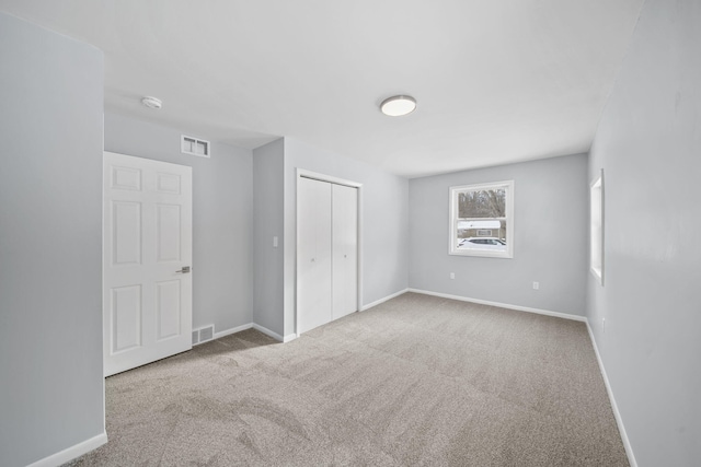 unfurnished bedroom featuring carpet floors and a closet