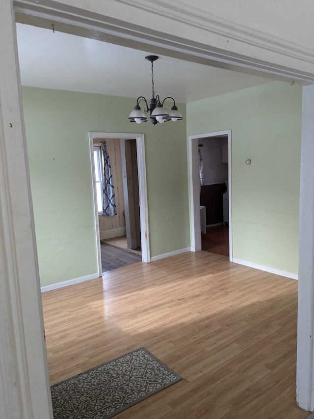 unfurnished dining area featuring hardwood / wood-style floors and an inviting chandelier