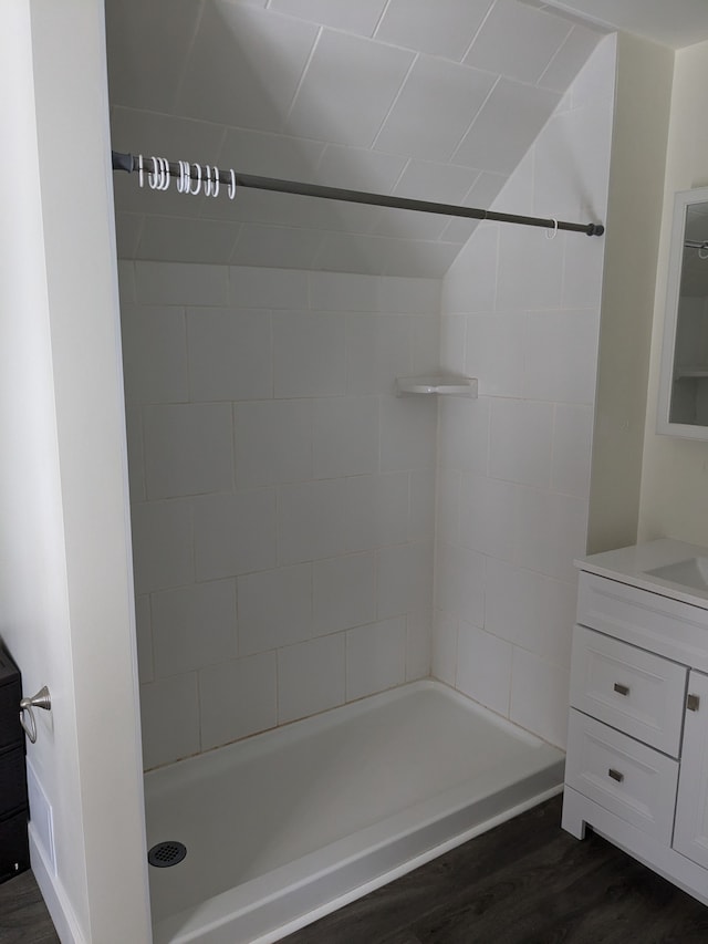 bathroom featuring vanity, hardwood / wood-style floors, and a tile shower