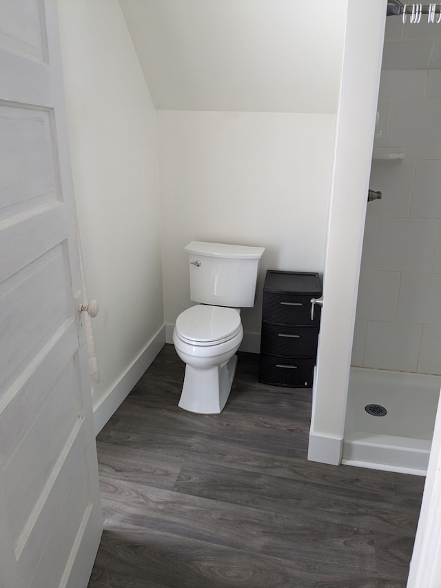 bathroom featuring tiled shower, toilet, and hardwood / wood-style floors