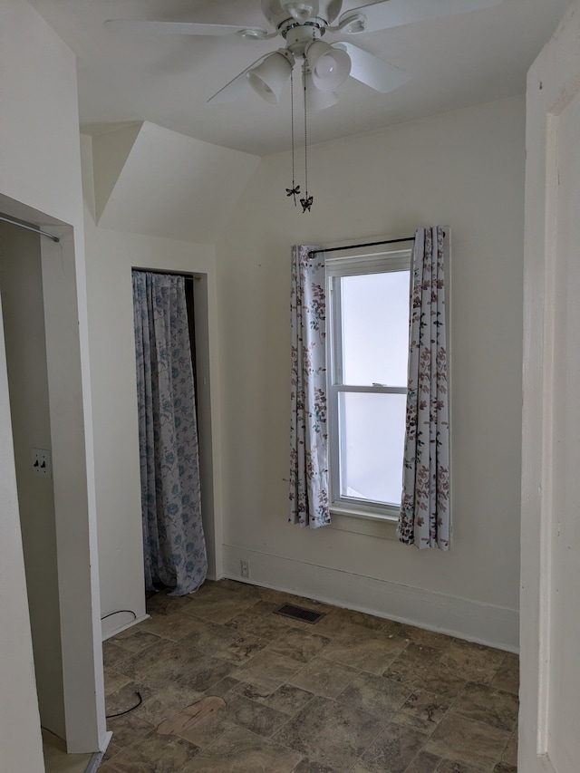 unfurnished room featuring lofted ceiling and ceiling fan