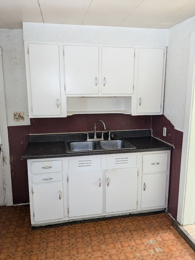 kitchen featuring white cabinetry and sink