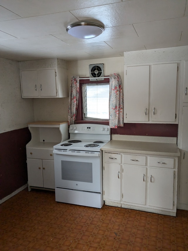 kitchen featuring electric stove and white cabinets