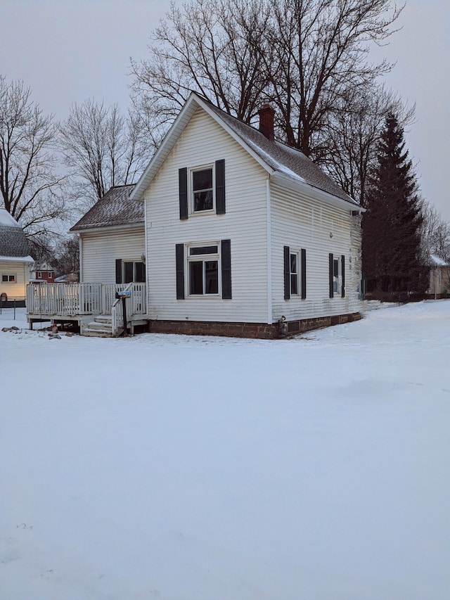 snow covered house featuring a deck