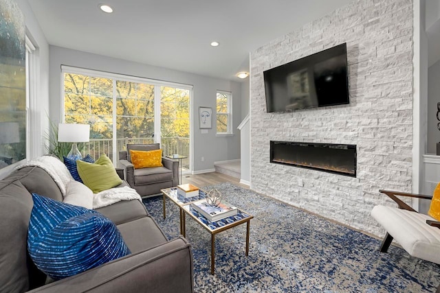 living room featuring hardwood / wood-style floors and a stone fireplace