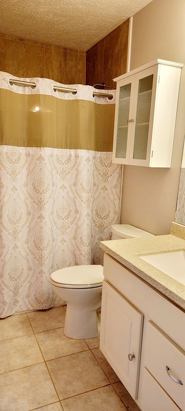 bathroom featuring vanity, tile patterned floors, and toilet