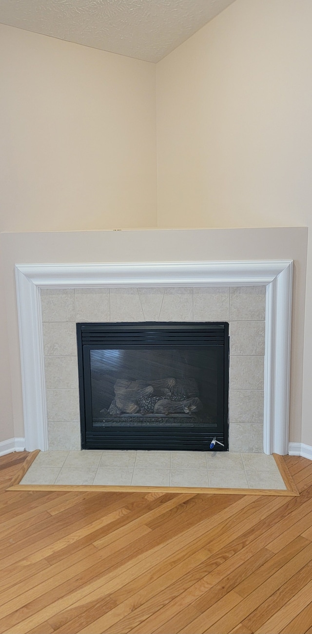 details with hardwood / wood-style flooring and a fireplace