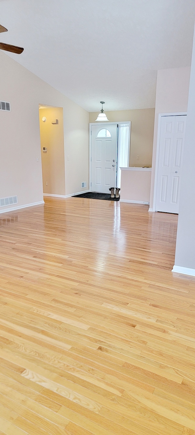 unfurnished room with ceiling fan, vaulted ceiling, and light hardwood / wood-style flooring