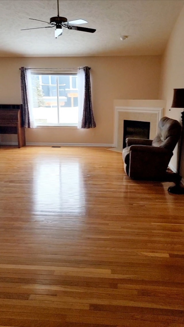 unfurnished living room featuring ceiling fan and light wood-type flooring