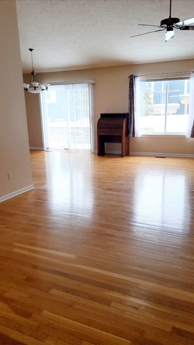 unfurnished living room featuring ceiling fan, plenty of natural light, and light hardwood / wood-style floors