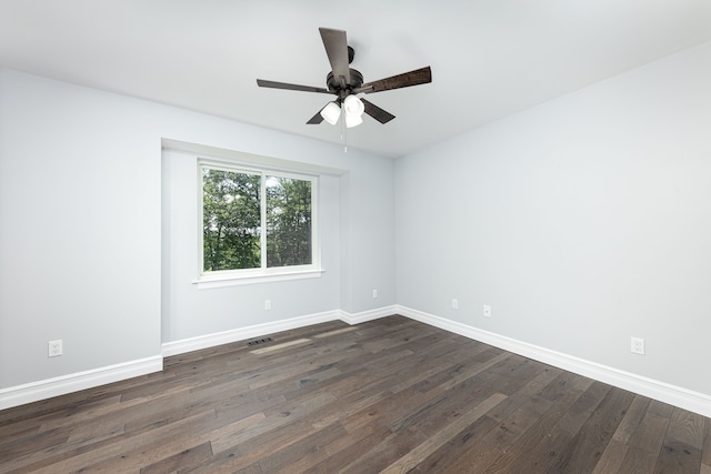 spare room featuring ceiling fan and dark wood-type flooring