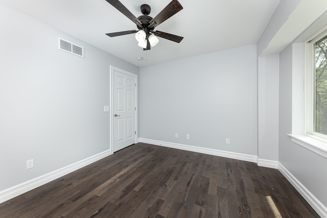 unfurnished room featuring dark wood-type flooring, ceiling fan, and plenty of natural light