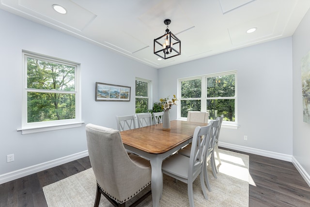 dining area with dark wood-type flooring and a chandelier