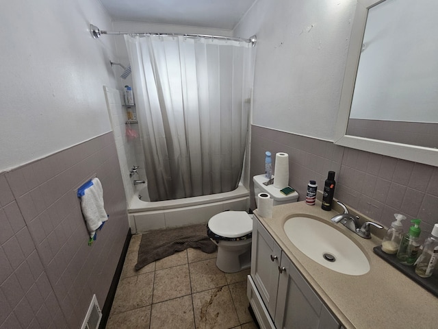 full bathroom with tile patterned flooring, vanity, tile walls, toilet, and shower / bath combo with shower curtain