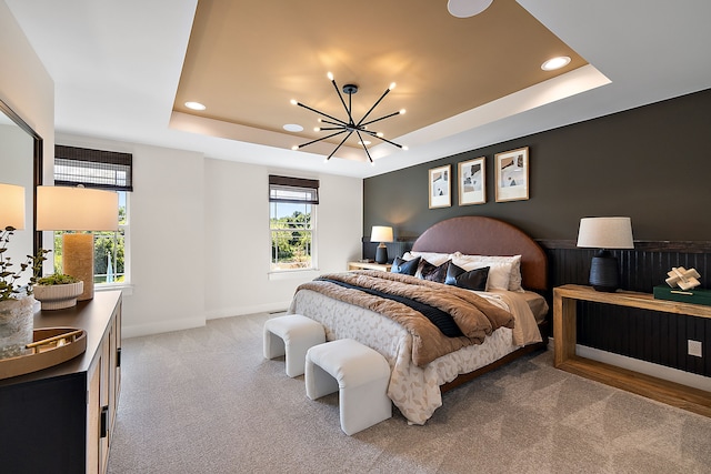 carpeted bedroom with a notable chandelier, a raised ceiling, and multiple windows