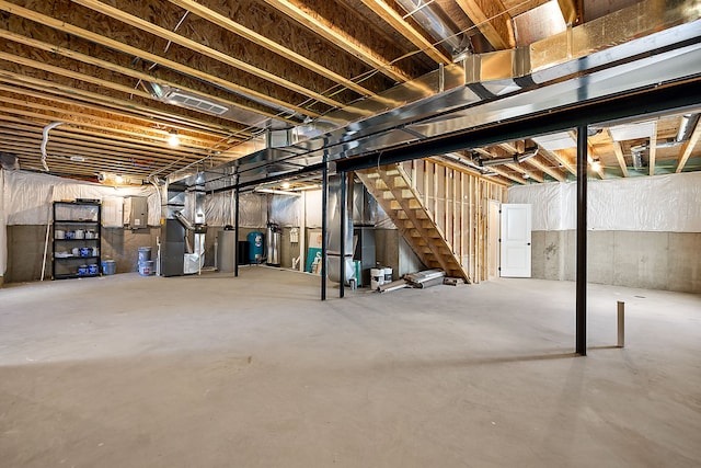 basement with electric panel, heating unit, and gas water heater