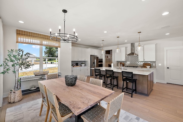 dining room with light hardwood / wood-style floors and a notable chandelier