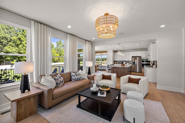 living room with a notable chandelier and light hardwood / wood-style floors