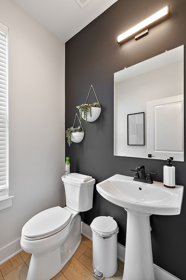 bathroom with toilet and hardwood / wood-style flooring