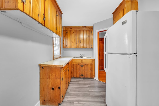 kitchen with sink, white refrigerator, and light hardwood / wood-style flooring