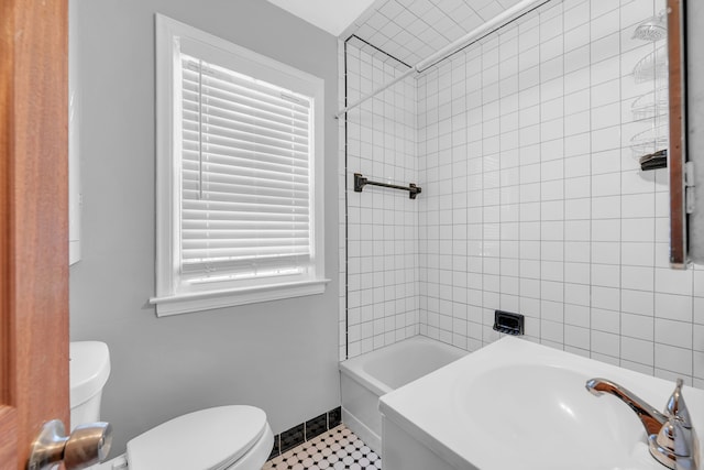 full bathroom with sink, toilet, tiled shower / bath combo, and tile patterned flooring