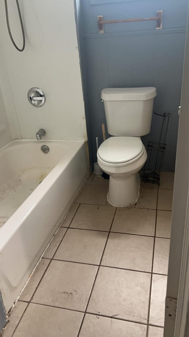 bathroom featuring toilet, tile patterned flooring, and bathing tub / shower combination