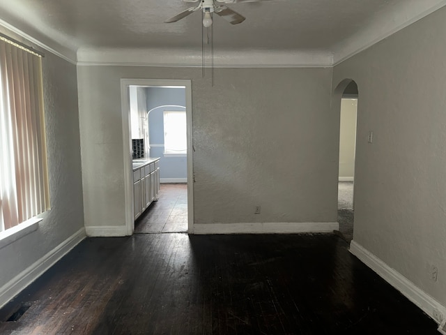 empty room with hardwood / wood-style flooring, crown molding, and ceiling fan