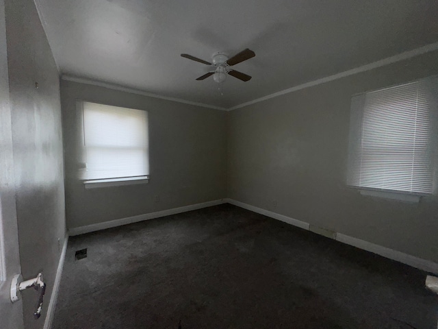 spare room with ceiling fan, dark carpet, and ornamental molding