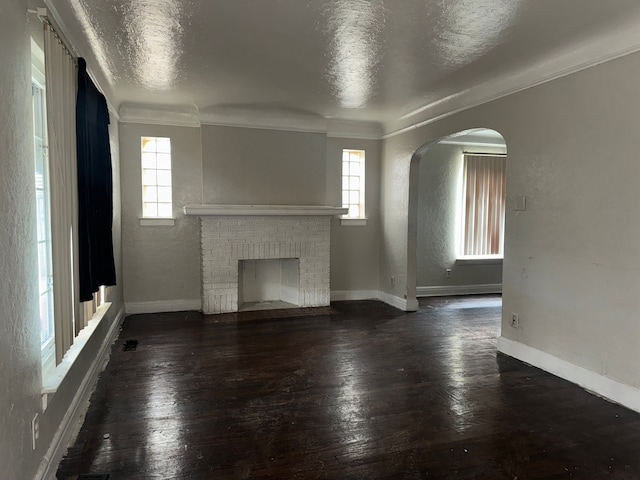 unfurnished living room with dark wood-type flooring, a textured ceiling, and a fireplace