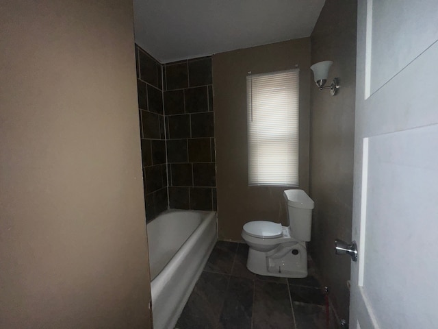 bathroom featuring tile patterned floors, toilet, and bathing tub / shower combination