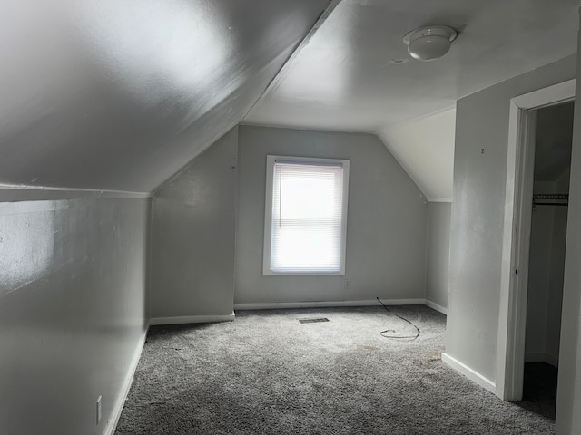 bonus room with carpet floors and vaulted ceiling