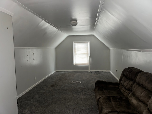 additional living space featuring vaulted ceiling and dark carpet