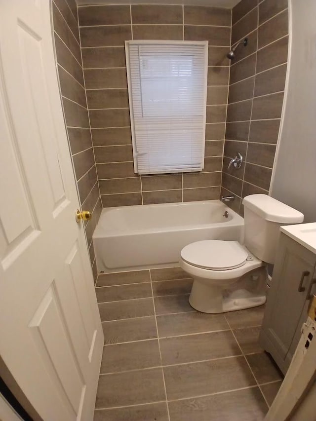 full bathroom featuring vanity, toilet, tile patterned floors, and tiled shower / bath combo