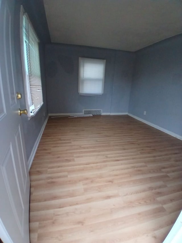 empty room with light hardwood / wood-style flooring