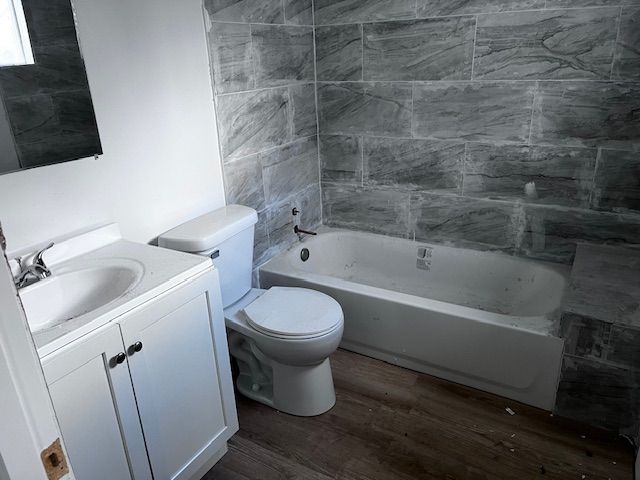 bathroom featuring toilet, vanity, and wood-type flooring