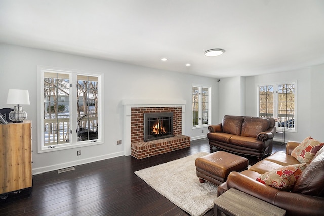 living room with dark hardwood / wood-style flooring and a fireplace