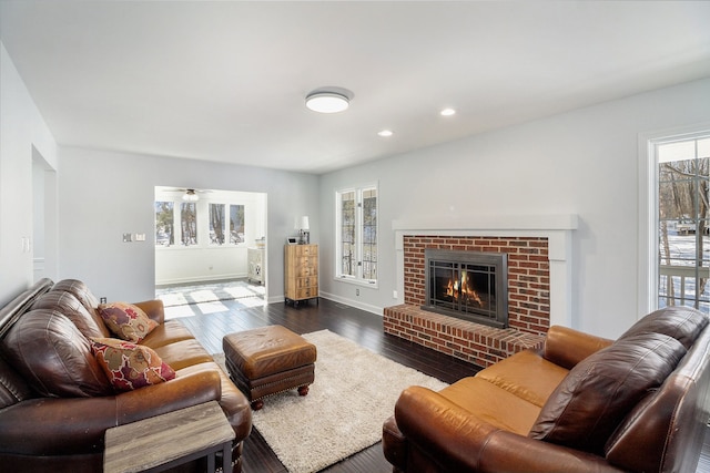 living room with dark hardwood / wood-style floors and a brick fireplace