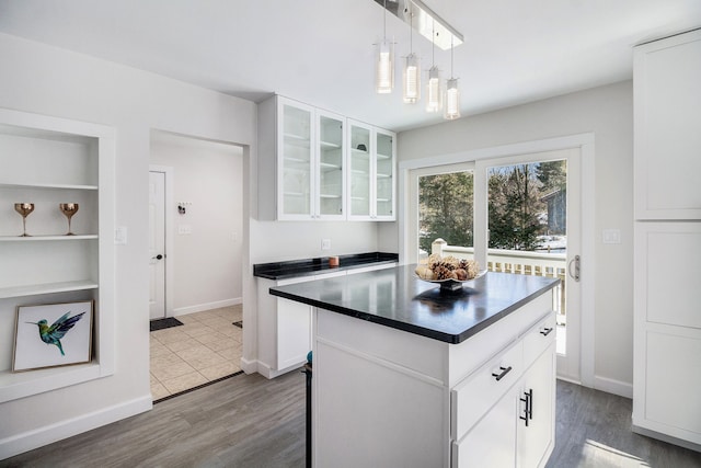 kitchen featuring white cabinetry, pendant lighting, a center island, and hardwood / wood-style flooring