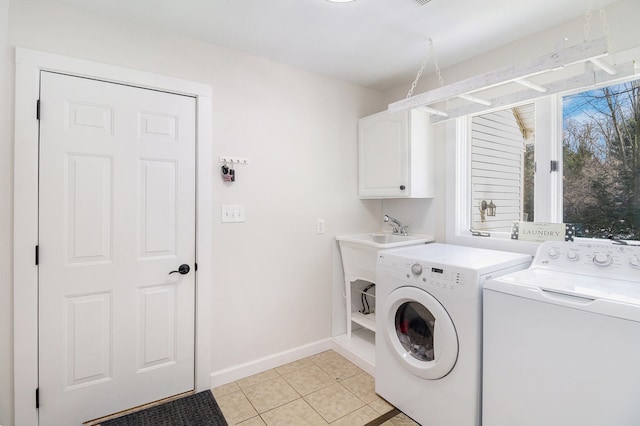 washroom featuring cabinets, sink, light tile patterned floors, and washing machine and clothes dryer